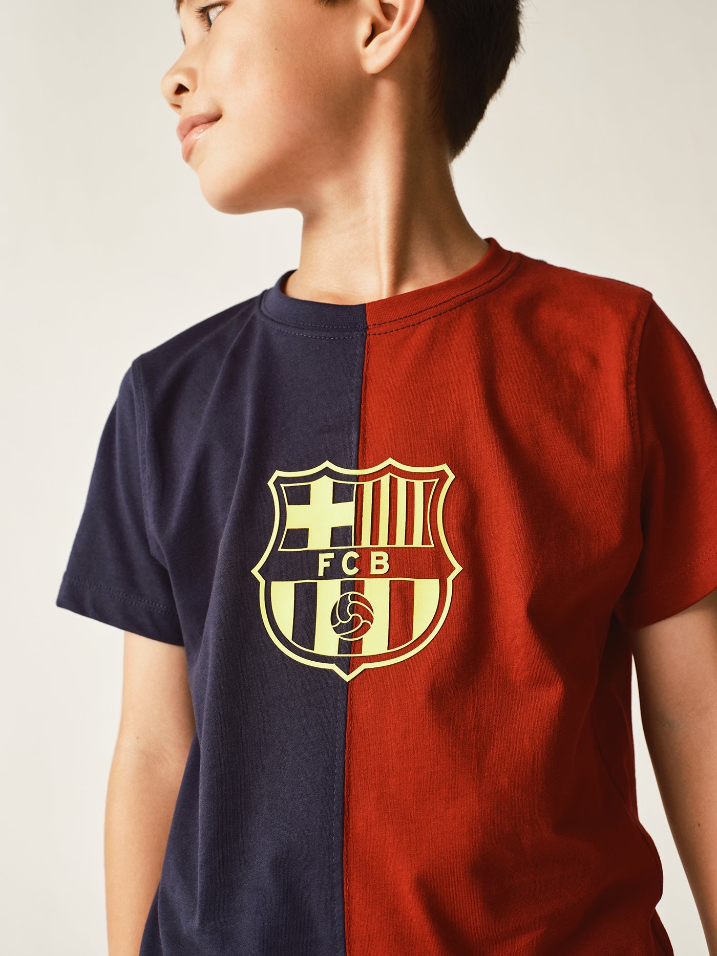 half navy and half red FC Barcelona t-shirt with a large vintage-style club crest in the center.