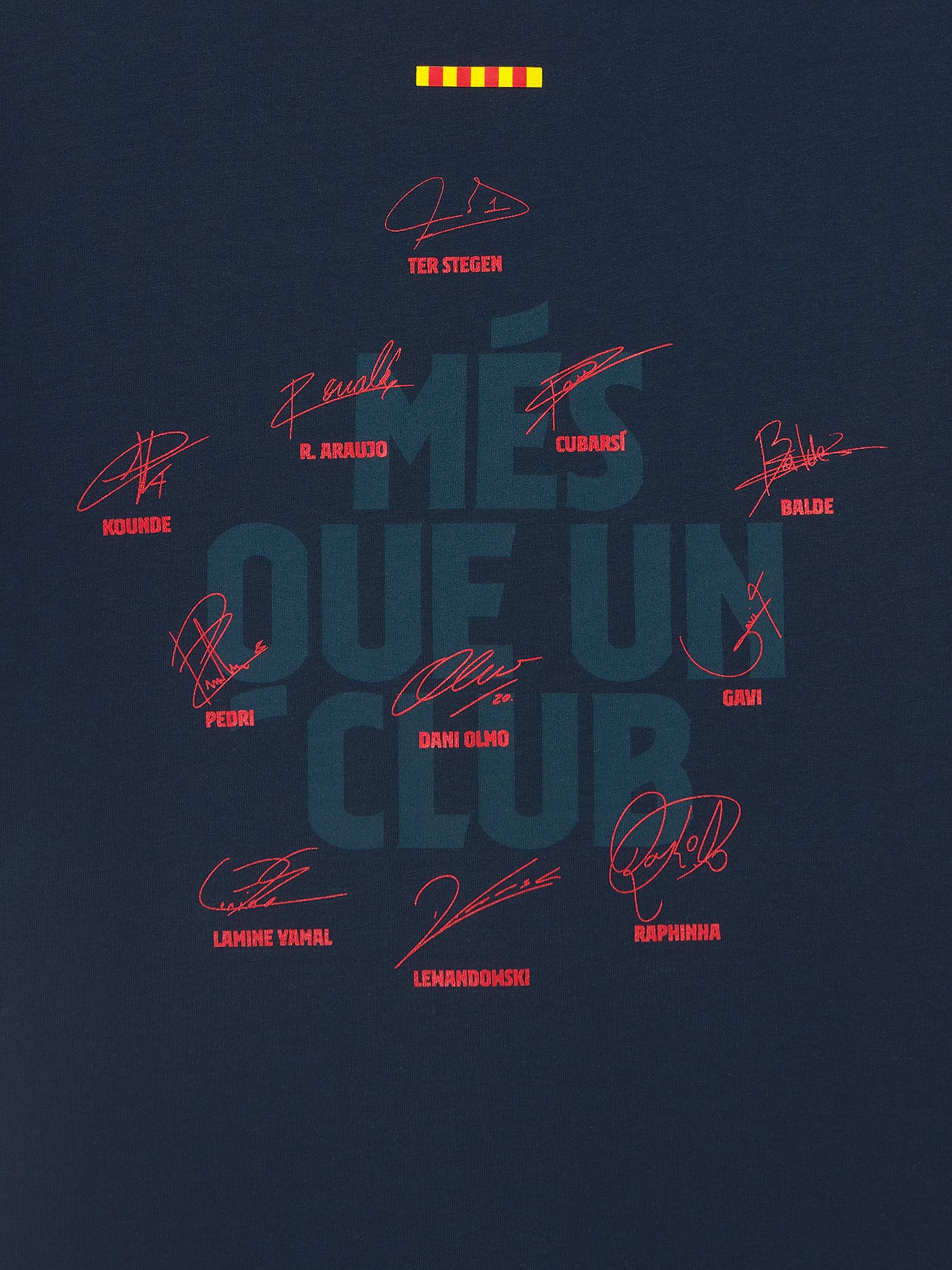 Back view of a navy blue FC Barcelona t-shirt featuring the phrase "MÉS QUE UN CLUB" in large, dark typography. Surrounding the text are red player autographs and jersey numbers, along with four yellow and red vertical bars representing the Catalan flag (senyera) near the neck.