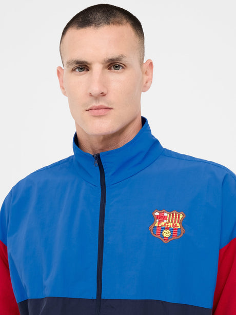 Color-block windbreaker in blue, red, and navy with FC Barcelona crest on the chest.