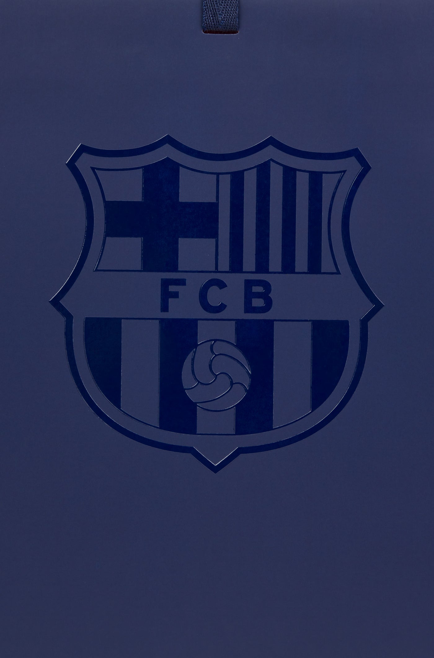 Dark blue FC Barcelona gift bag with glossy club crest on the front and dark blue handles, featuring a red interior.