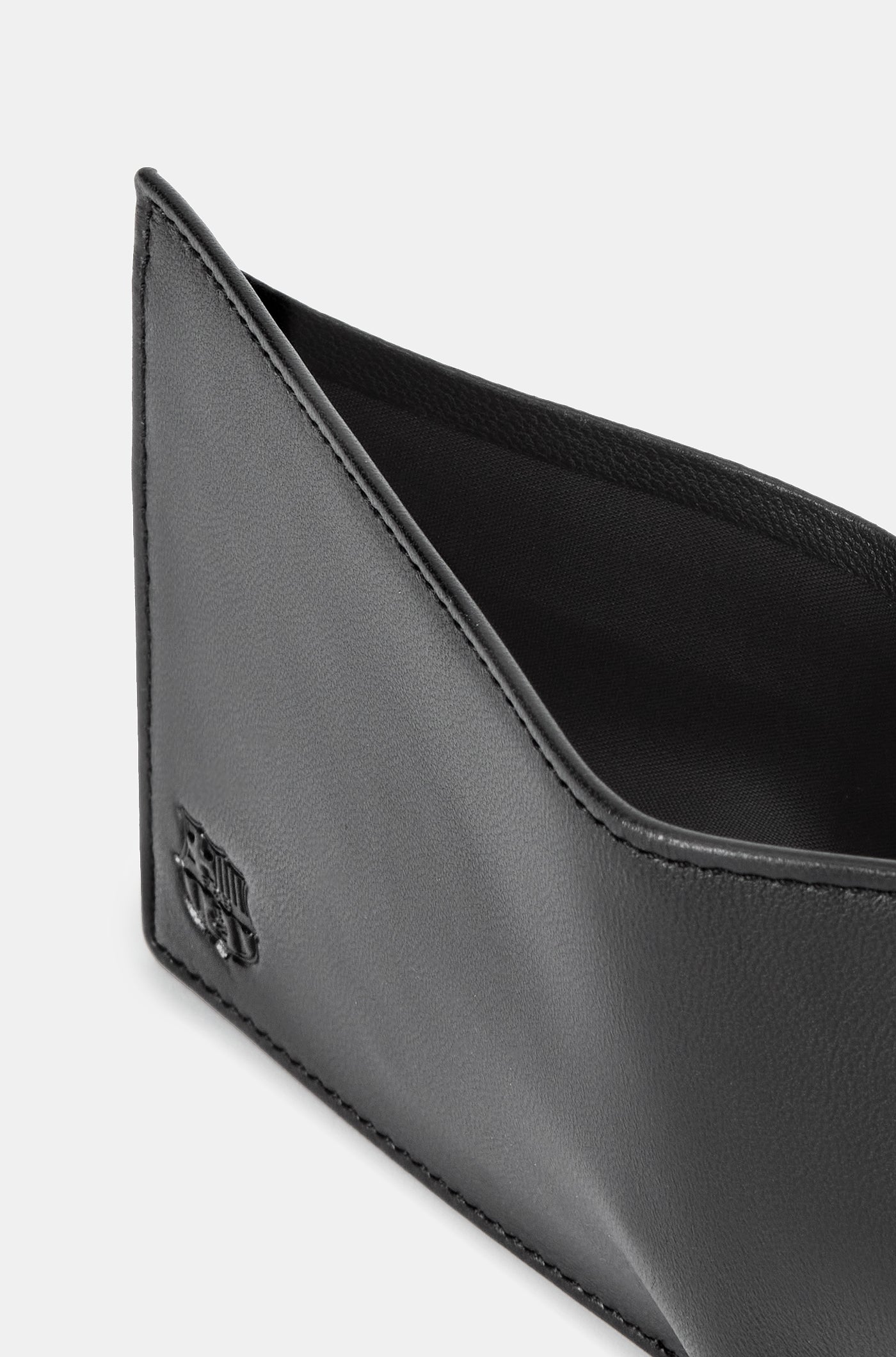 Close-up of a black leather wallet with an embossed FC Barcelona logo on the corner.