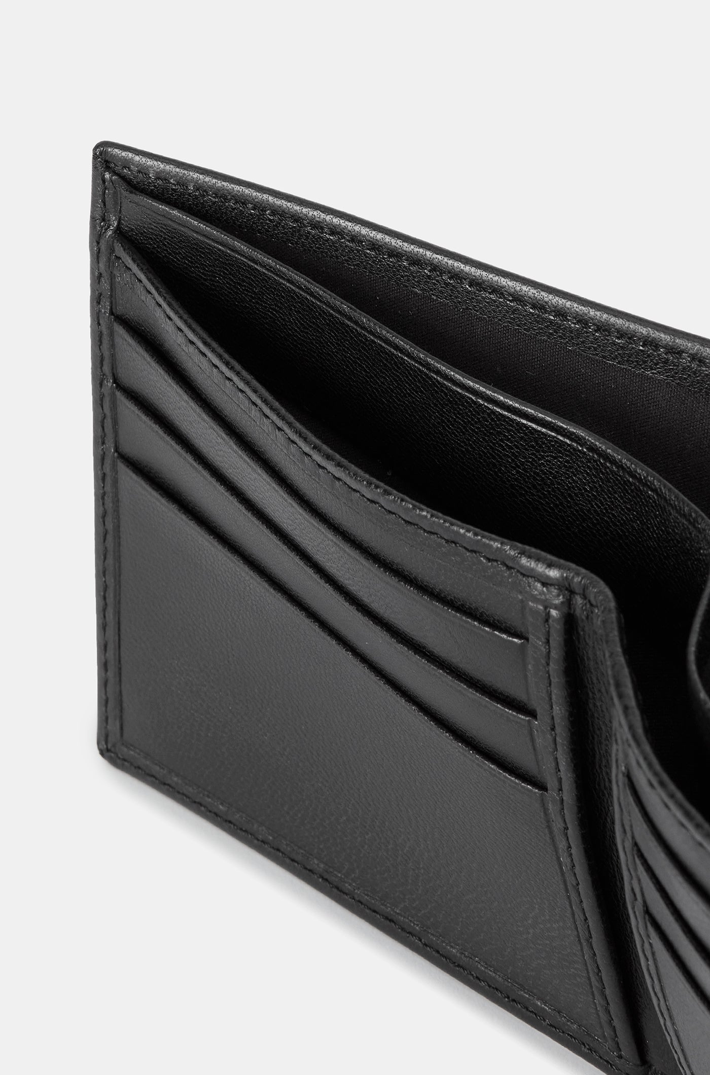 Close-up of a black leather wallet with an embossed FC Barcelona logo on the corner.