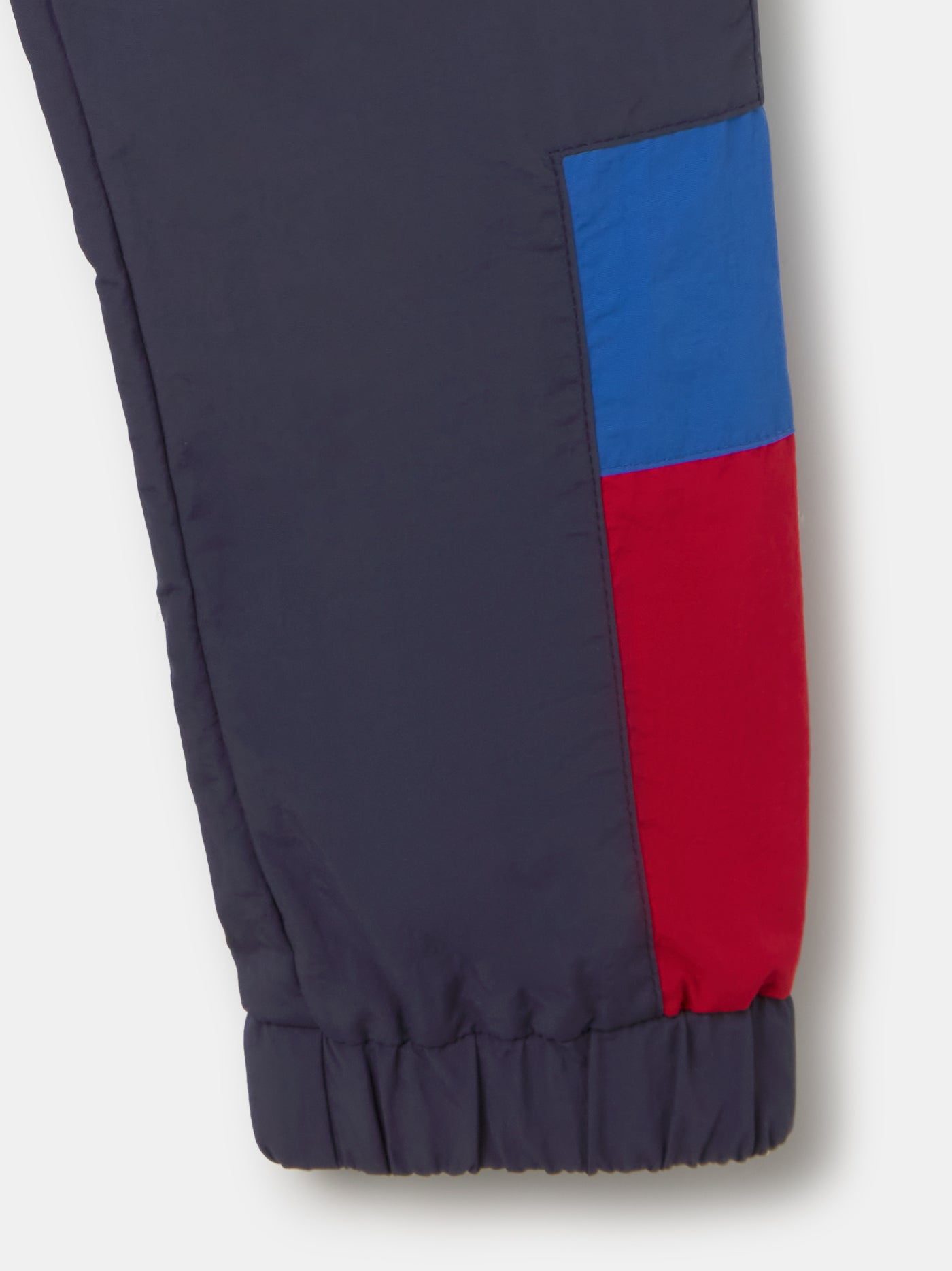 Navy jogger pants with FC Barcelona crest on the upper leg and red and blue color blocks on the knees.