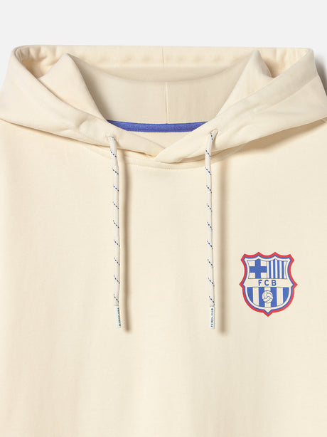 Back of a light hoodie featuring a vibrant FC Barcelona graphic design in blue, red, and white. The collage includes elements like a trophy, football, “GOAL,” “DIA DE PARTIT,” “1899,” and the Barça crest. Surrounding the design are phrases like “FC BARCELONA,” “TOTS UNITS FEM FORÇA,” “SENTIMENT BLAUGRANA,” and “MÉS QUE UN CLUB.”