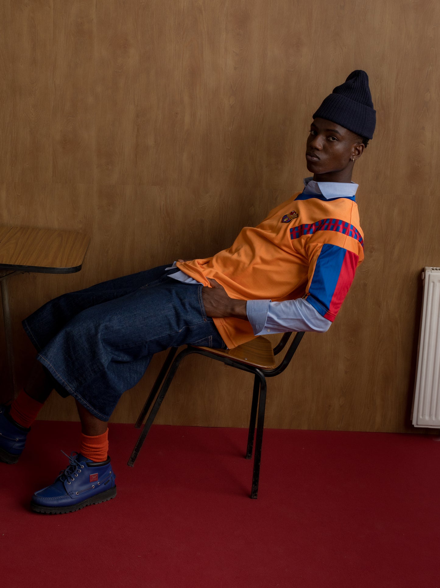 Orange retro-style FC Barcelona jersey with crest on the chest and red and blue details on the sleeves and shoulders.