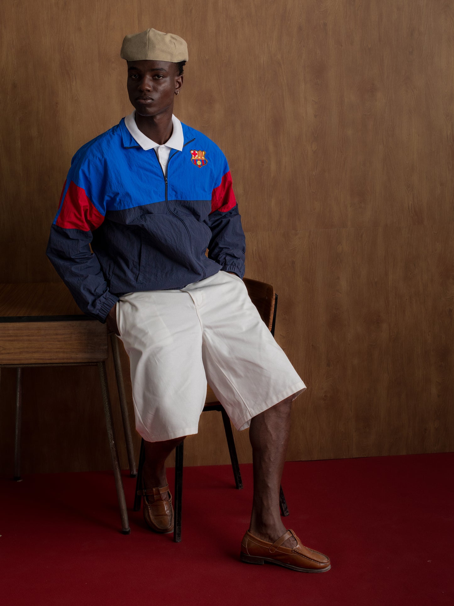 Color-block windbreaker in blue, red, and navy with FC Barcelona crest on the chest.