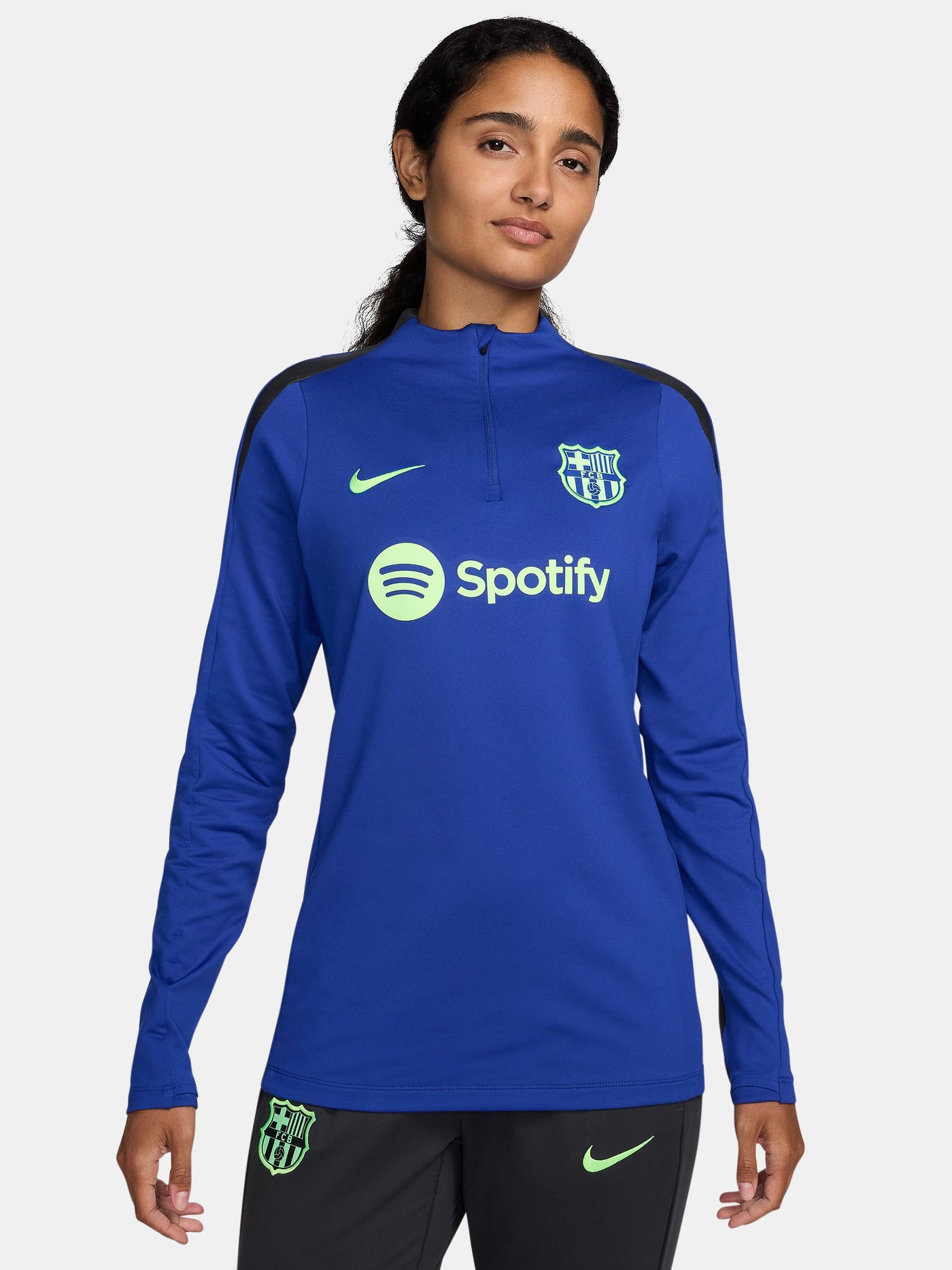 Women's FC Barcelona long-sleeve training top in vibrant royal blue with black shoulder accents, featuring light green Nike, Spotify, and club logos on the chest.