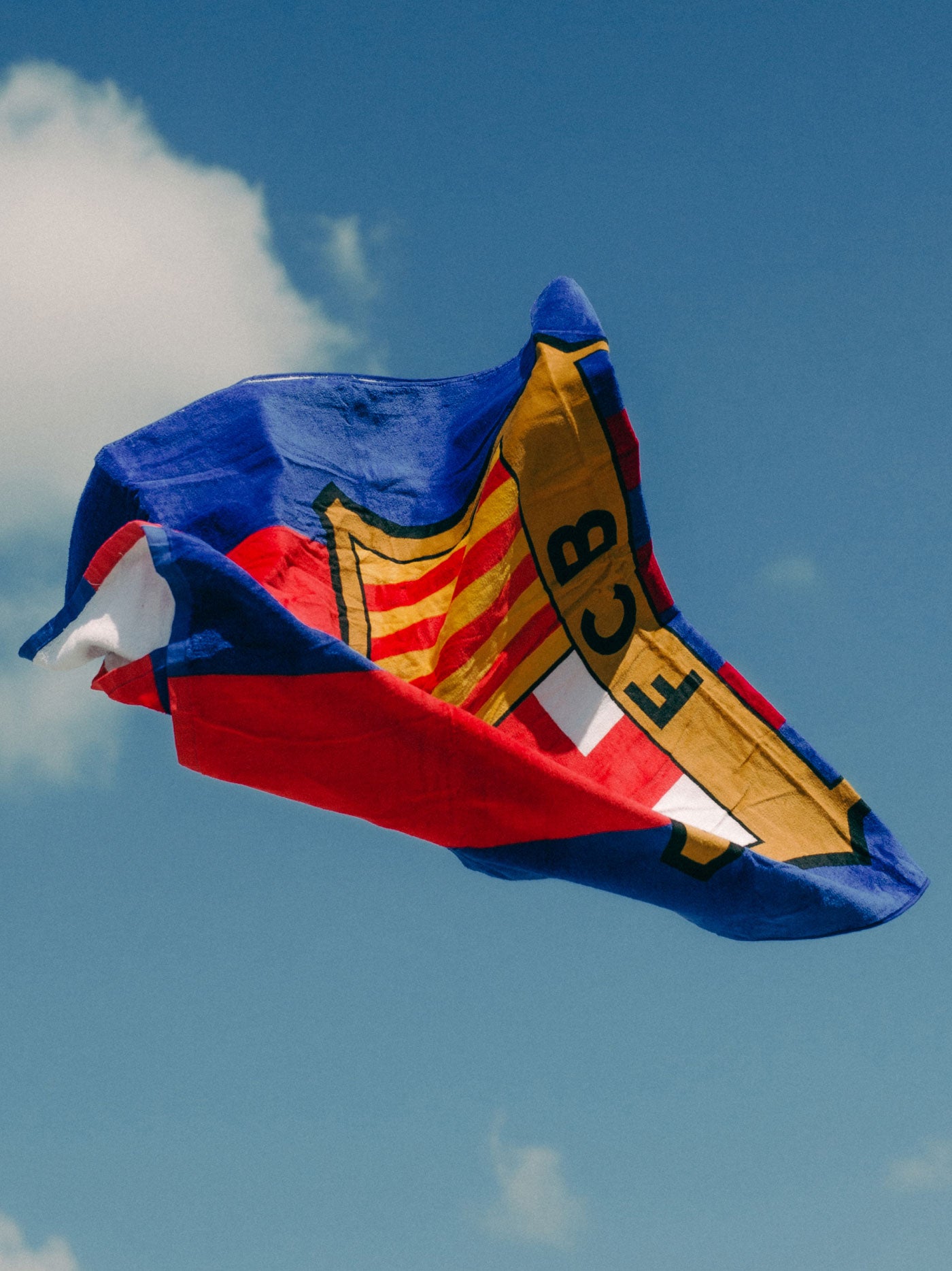 FC Barcelona beach towel featuring vertical blue and red stripes with a large central club crest.