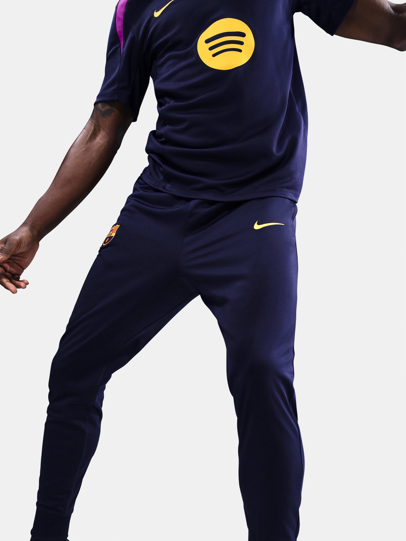 FC Barcelona tapered training pants in navy blue. Designed for performance and comfort with a slim fit, featuring the club crest and a yellow Nike swoosh on the front. Ideal for training sessions or casual wear.