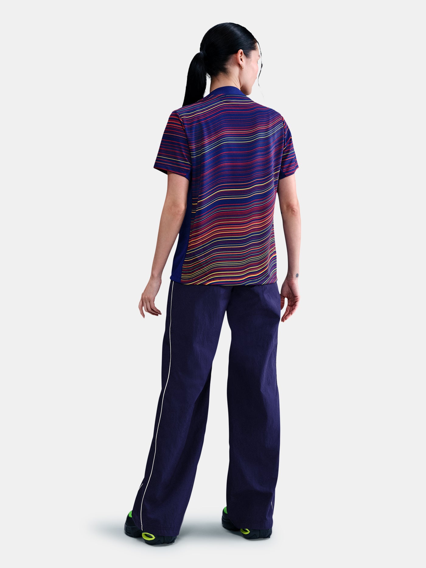 Women's FC Barcelona pre-match jersey with multicolor wave pattern, yellow Nike logo, club crest, and Spotify sponsor on the front.