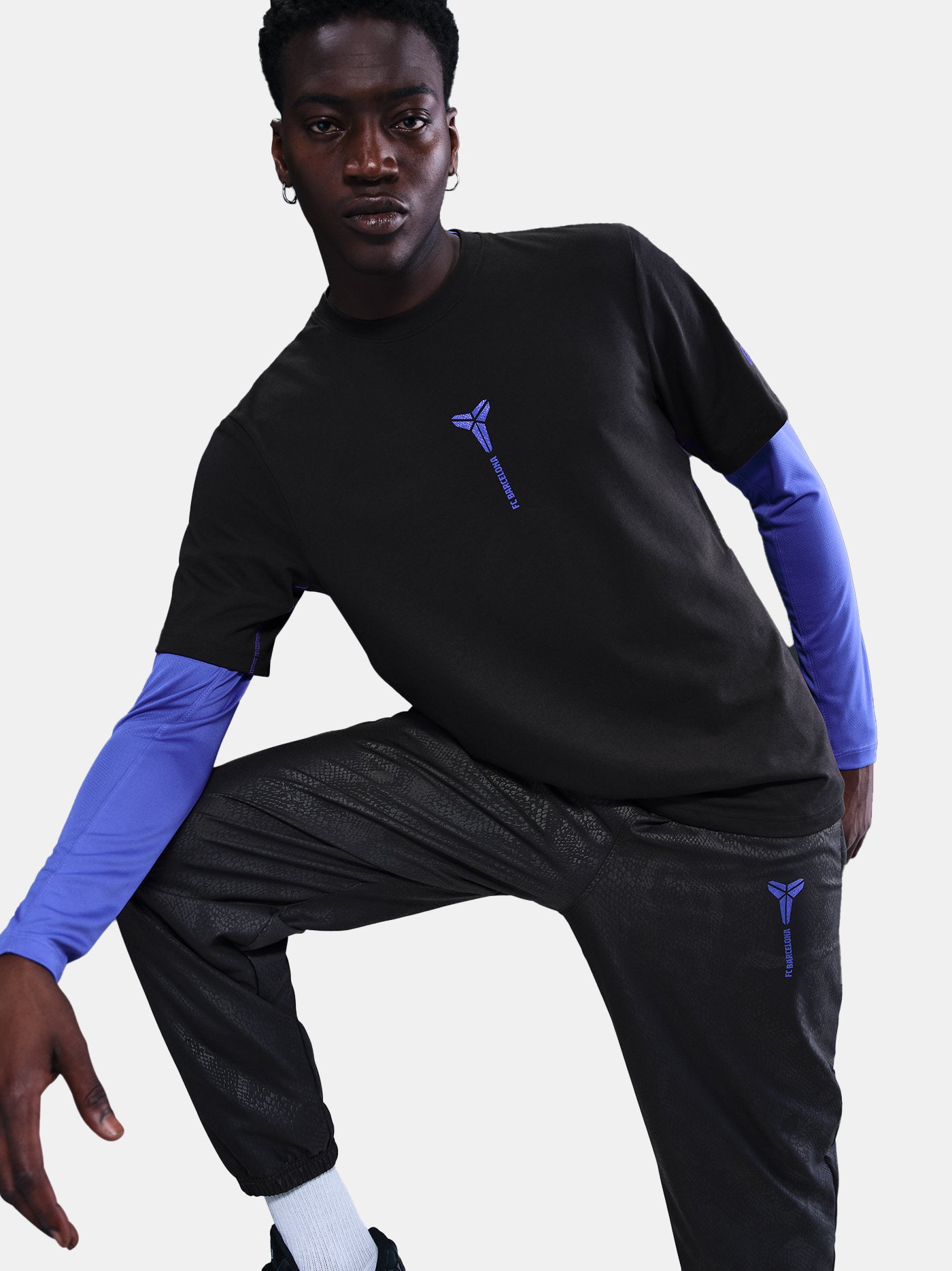 Black FC Barcelona T-shirt with blue Kobe Bryant logo on the chest, paired with black shorts featuring the same emblem.