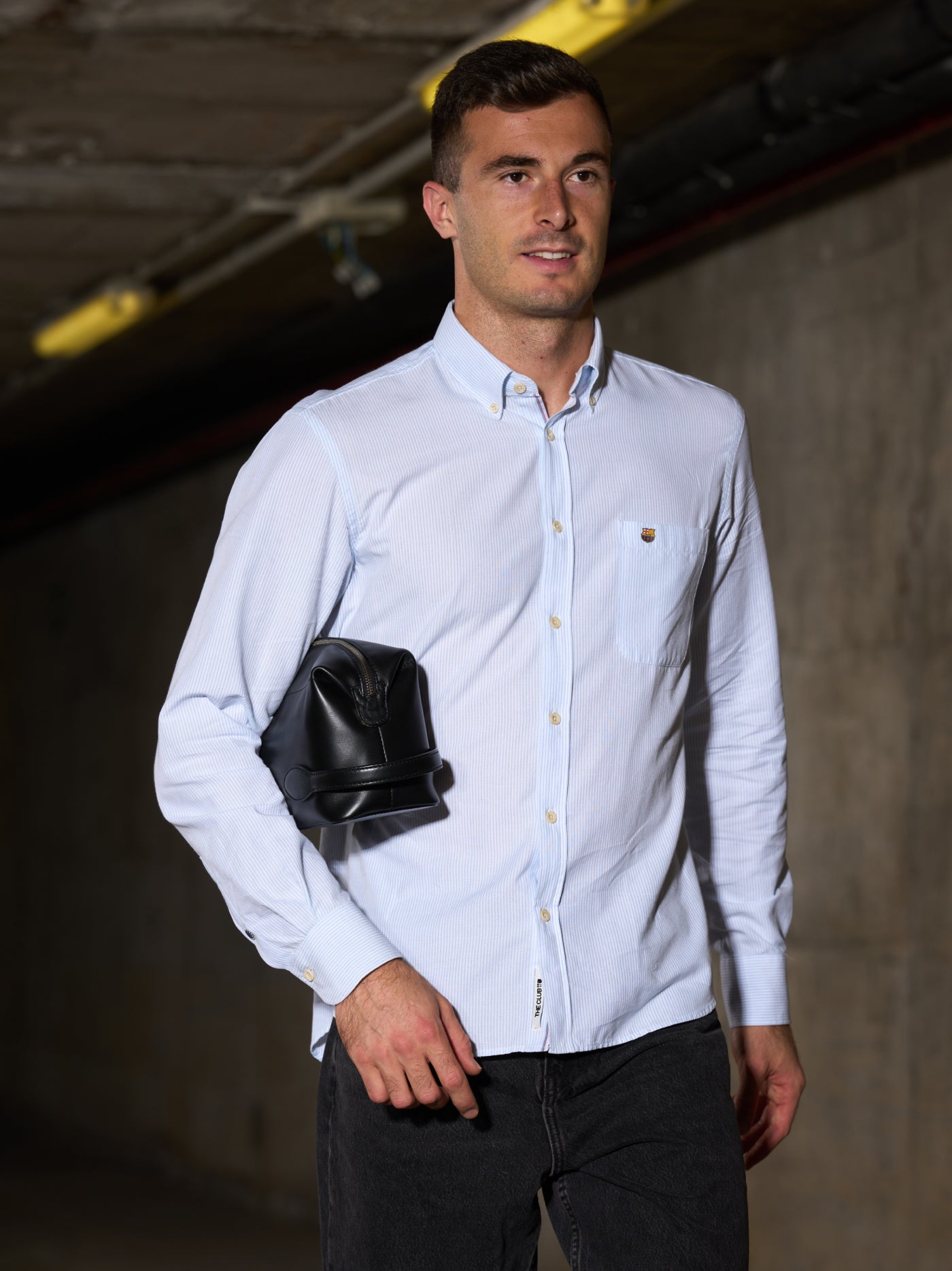 Black leather toiletry bag with a side handle and a silver zipper, featuring an embossed FC Barcelona logo.