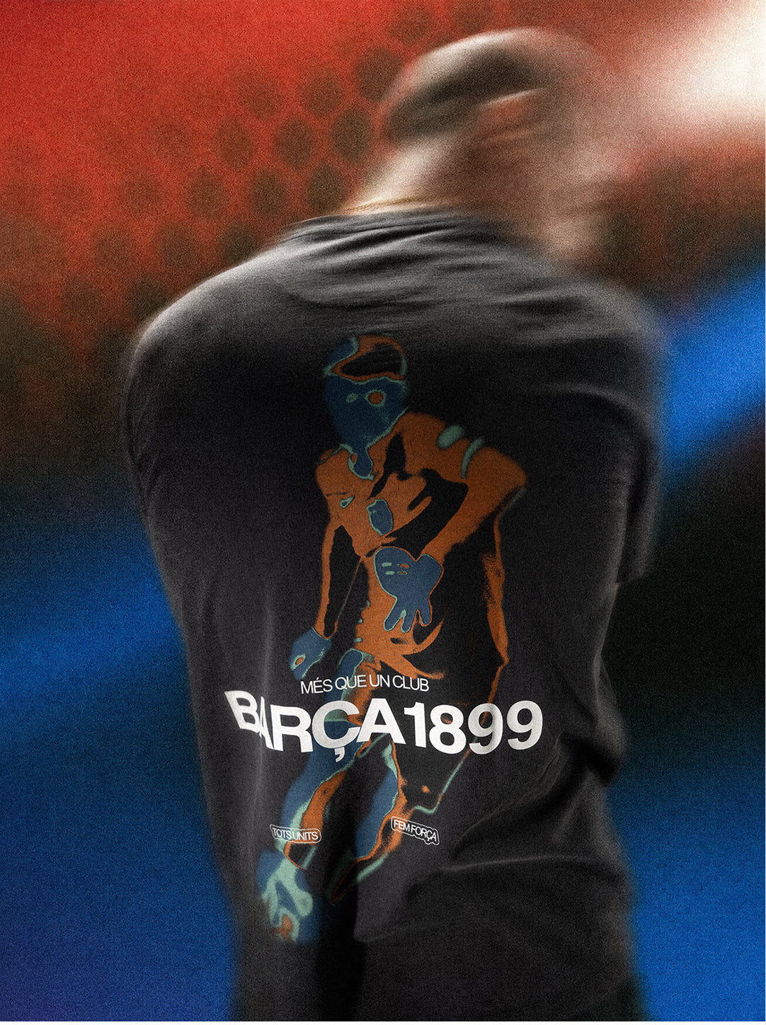 Back view of a black FC Barcelona T-shirt with a large graphic figure and the text “MÉS QUE UN CLUB BARÇA 1899” on the back.