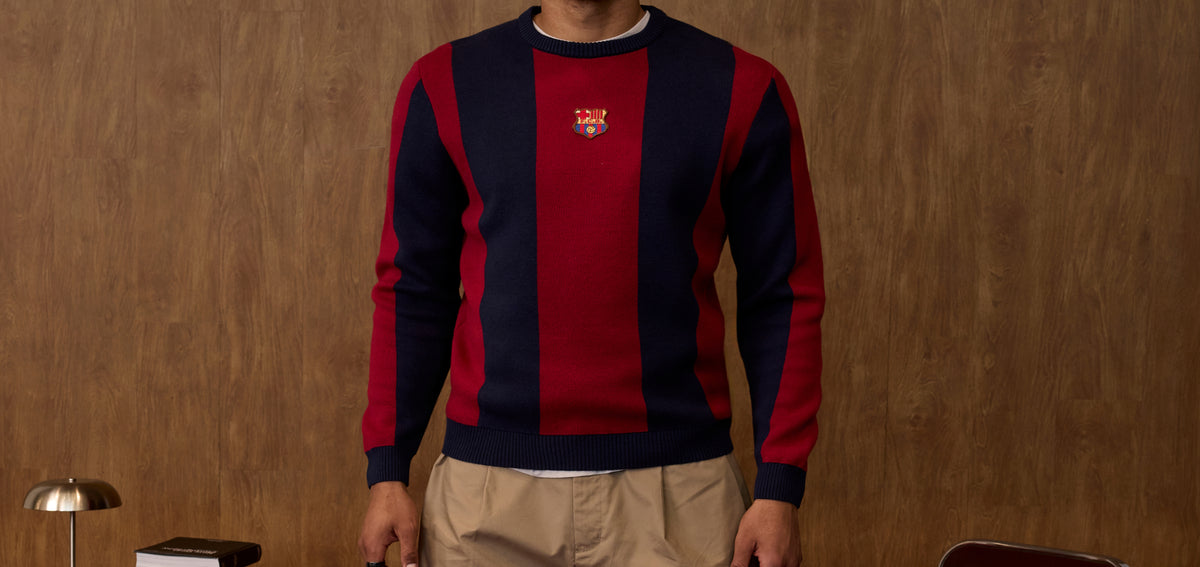 Front view of an FC Barcelona sweater with vertical red and navy stripes and the club crest centered on the chest