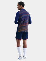 Person wearing a blue sports outfit with a patterned back on a white background