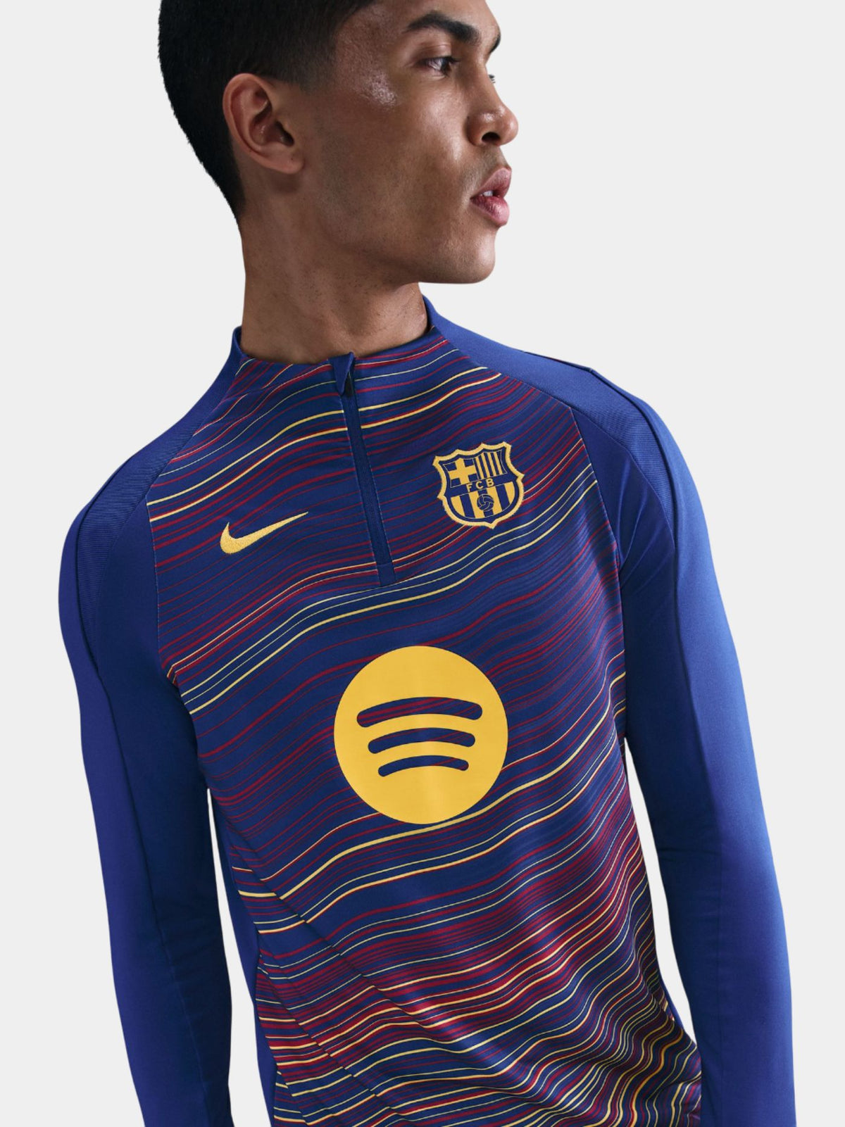Person wearing a sports jersey with a Spotify logo on a plain background
