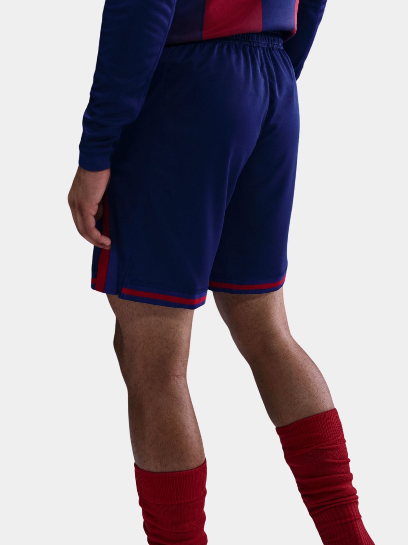 Person wearing blue shorts with red accents on a white background