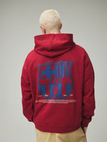 Model wearing a red FC Barcelona hoodie with crest in a lifestyle ecommerce image.