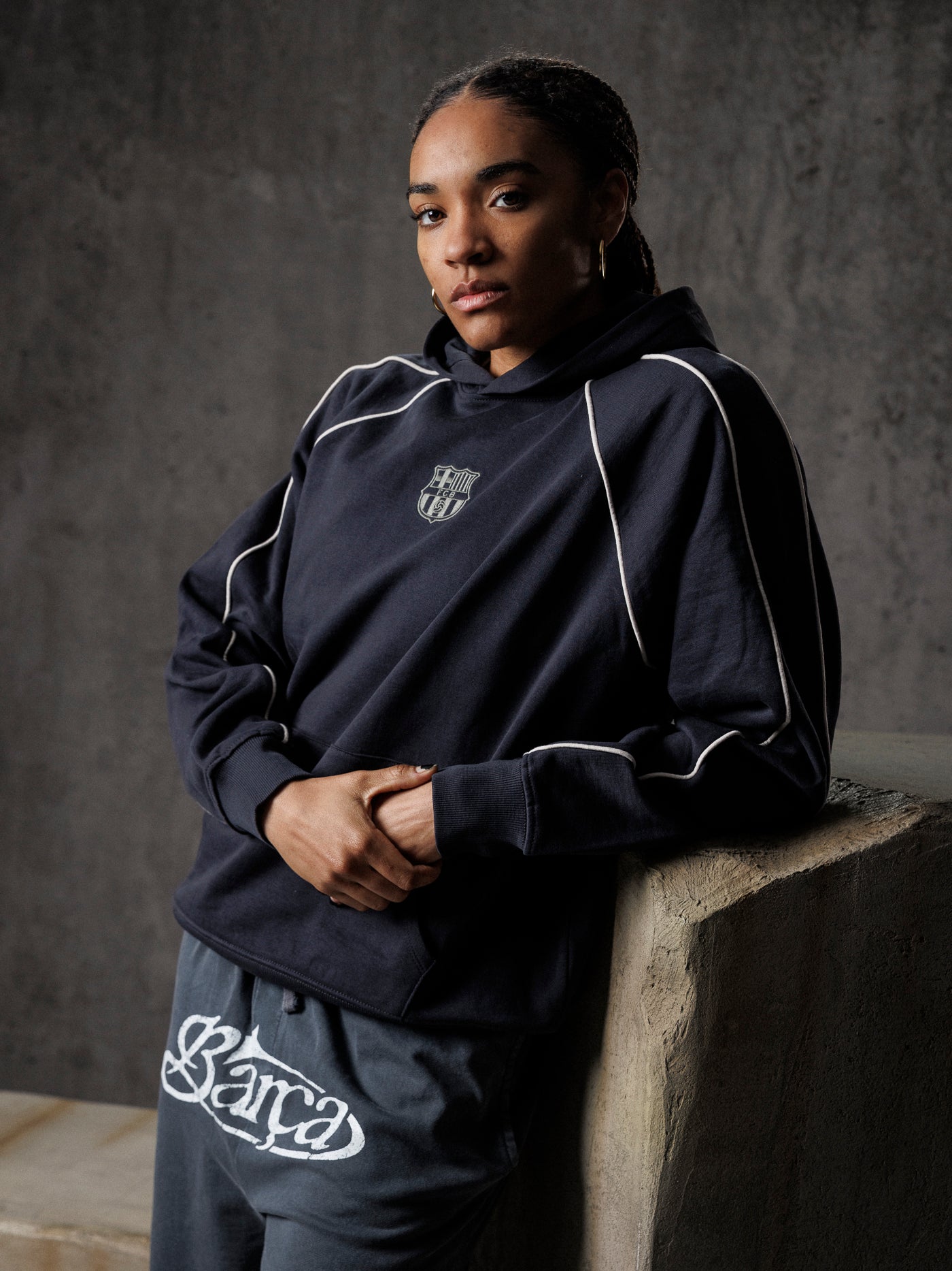 Person wearing a navy tracksuit with white accents against a gray background