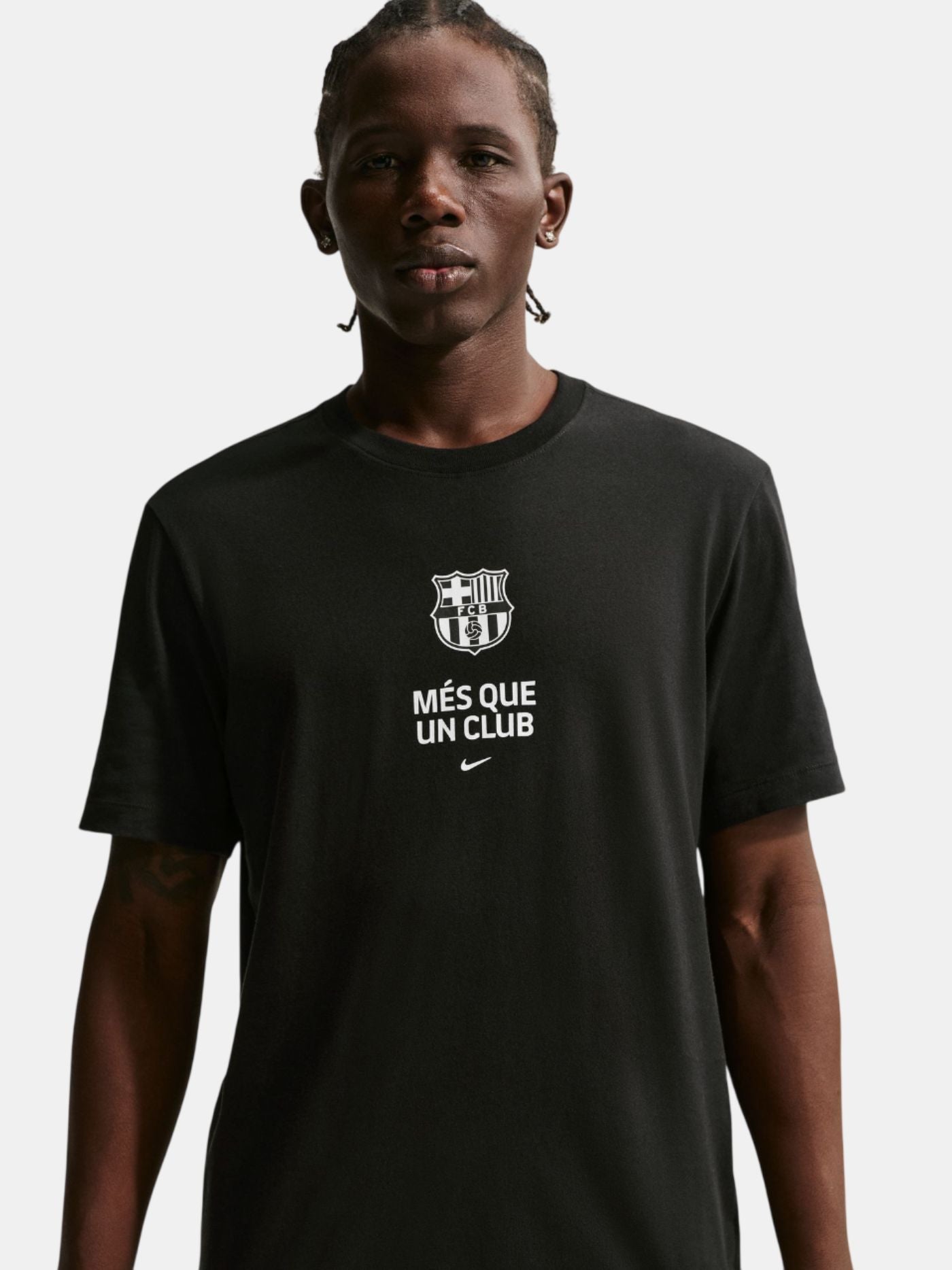 Person wearing a black t-shirt with a logo and text on a plain background