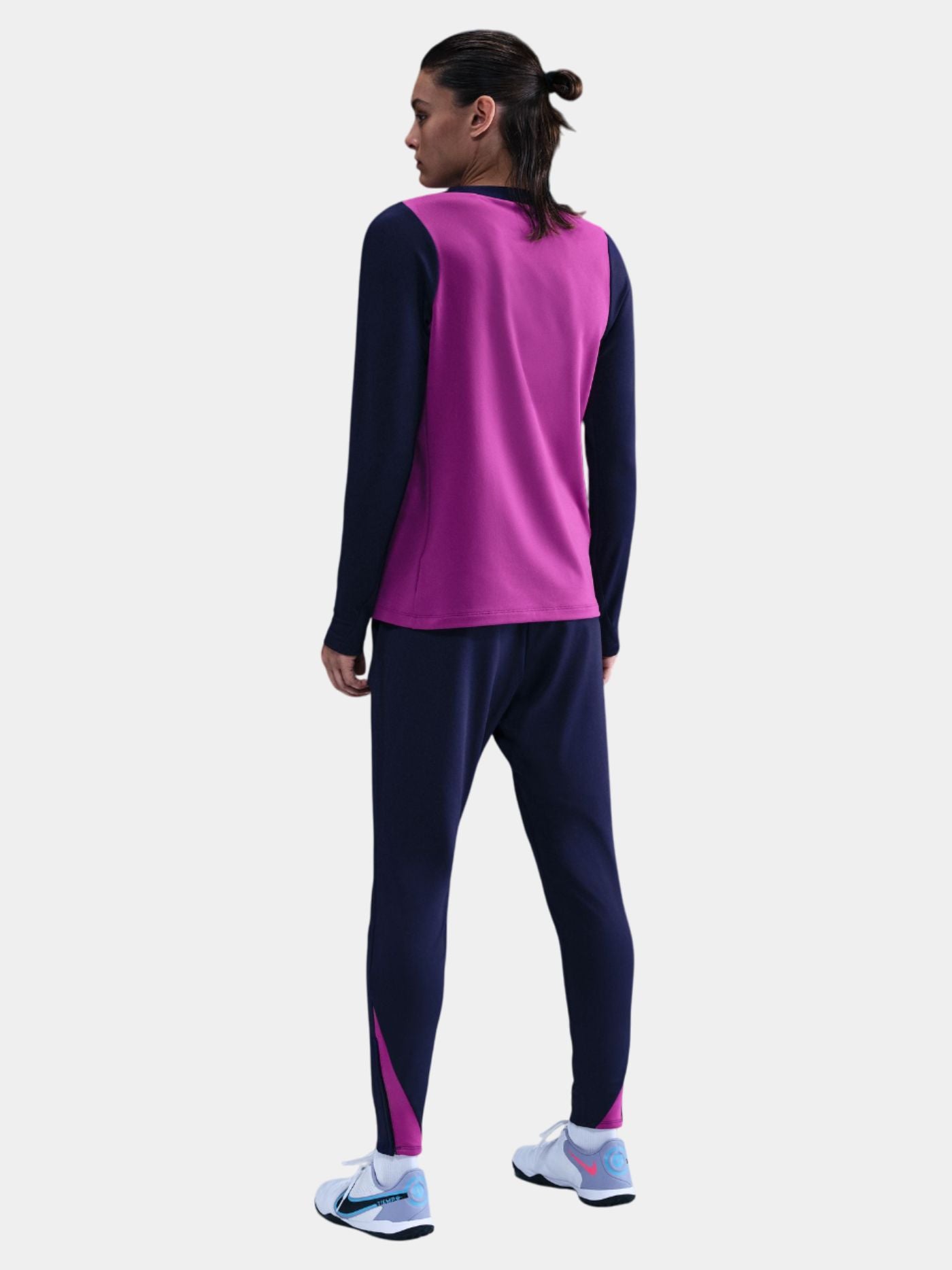 Woman wearing a FC Barcelona long-sleeve jersey in purple with navy sleeves, featuring the club crest, Nike logo, and Spotify sponsor in yellow.