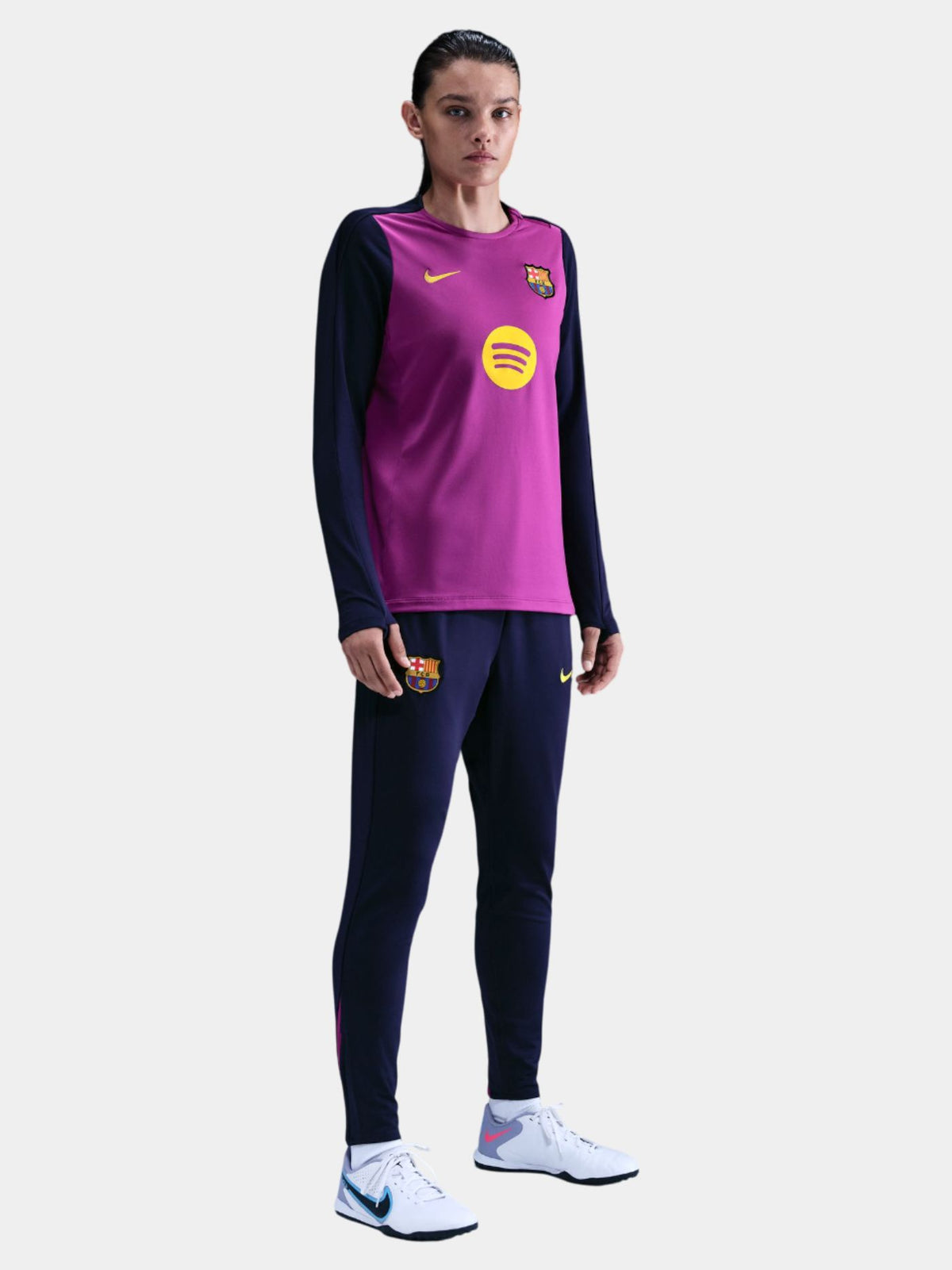 Woman wearing a FC Barcelona long-sleeve jersey in purple with navy sleeves, featuring the club crest, Nike logo, and Spotify sponsor in yellow.