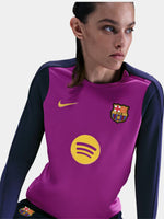 Woman wearing a FC Barcelona long-sleeve jersey in purple with navy sleeves, featuring the club crest, Nike logo, and Spotify sponsor in yellow.