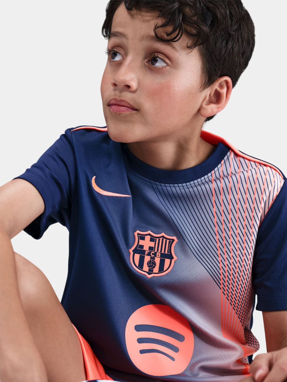 navy FC Barcelona jersey with coral geometric design, featuring the club crest, Nike logo, and Spotify sponsor.