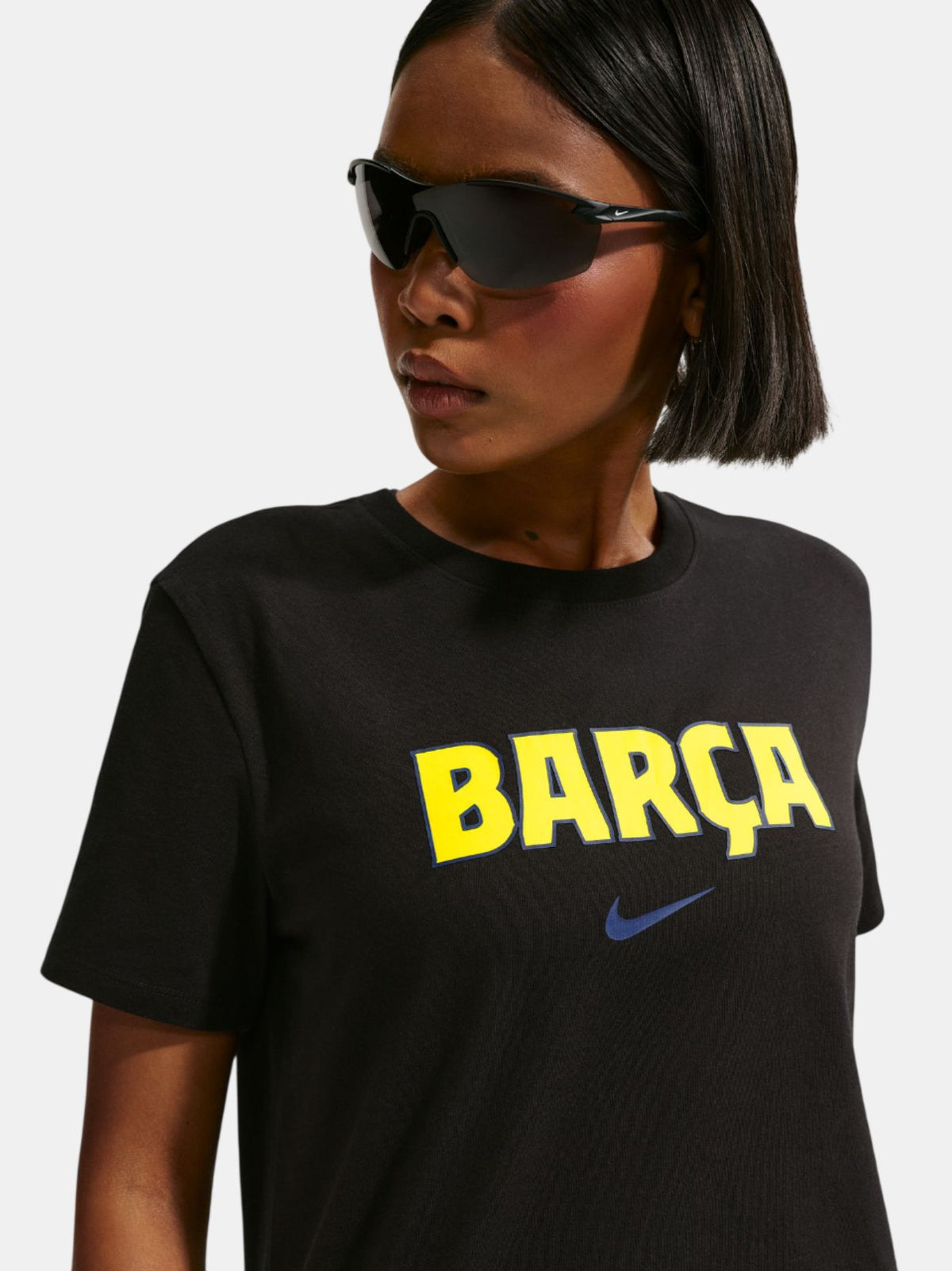 Person wearing a black t-shirt with 'BARça' in yellow and Nike logo.