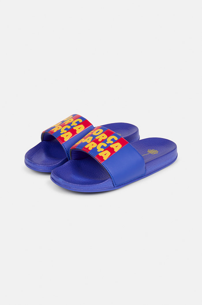 A pair of blue FC Barcelona slide sandals with red and yellow stripes on the straps, displaying the phrase "Força Barça" in bold yellow letters.