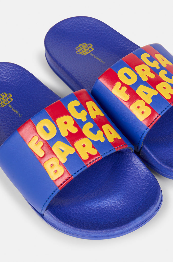 A pair of blue FC Barcelona slide sandals with red and yellow stripes on the straps, displaying the phrase "Força Barça" in bold yellow letters.