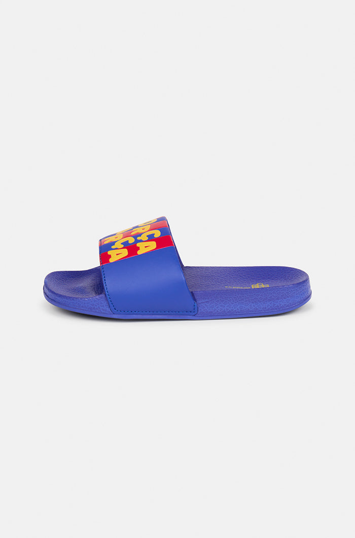 A pair of blue FC Barcelona slide sandals with red and yellow stripes on the straps, displaying the phrase "Força Barça" in bold yellow letters.