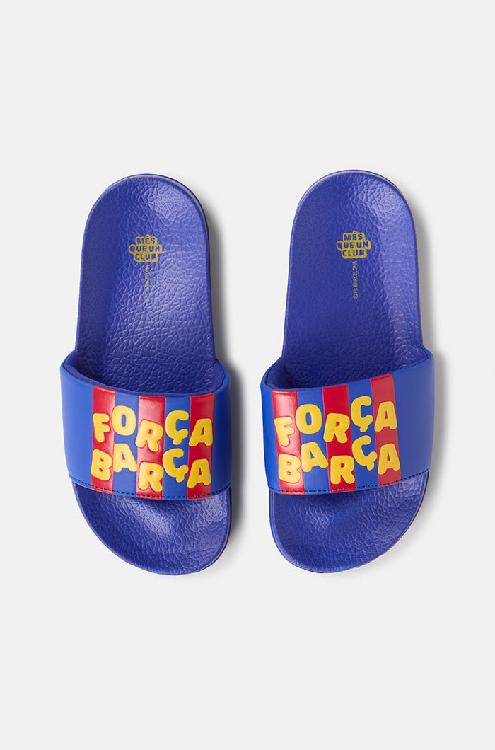 A pair of blue FC Barcelona slide sandals with red and yellow stripes on the straps, displaying the phrase "Força Barça" in bold yellow letters.