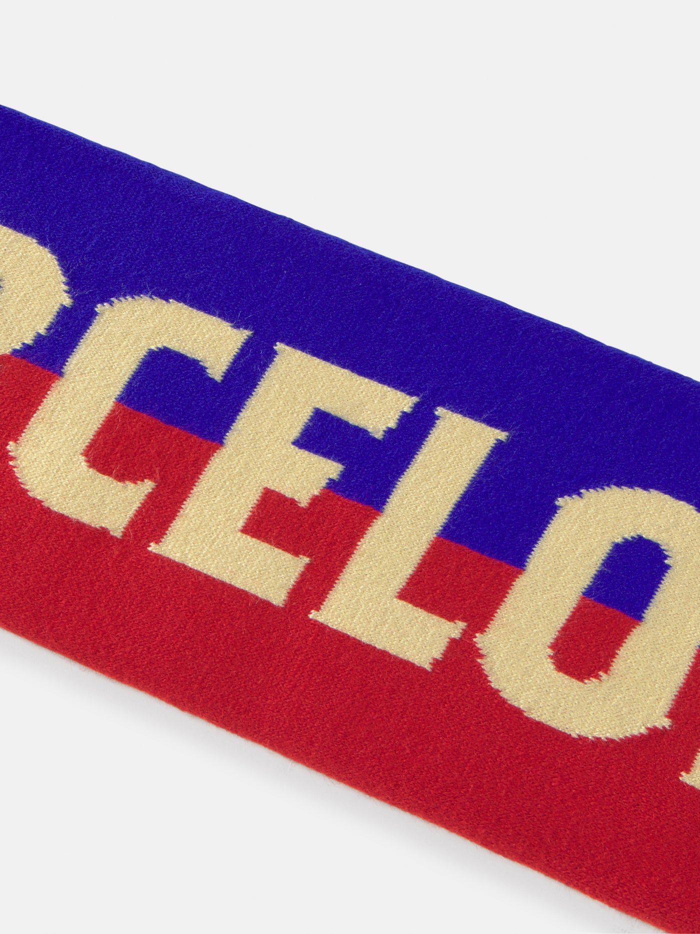FC Barcelona scarf featuring the club's crest, bold red and blue stripes, and the partial text "FC BARCELON" in beige, with a yellow and red Catalan flag detail across the middle.
