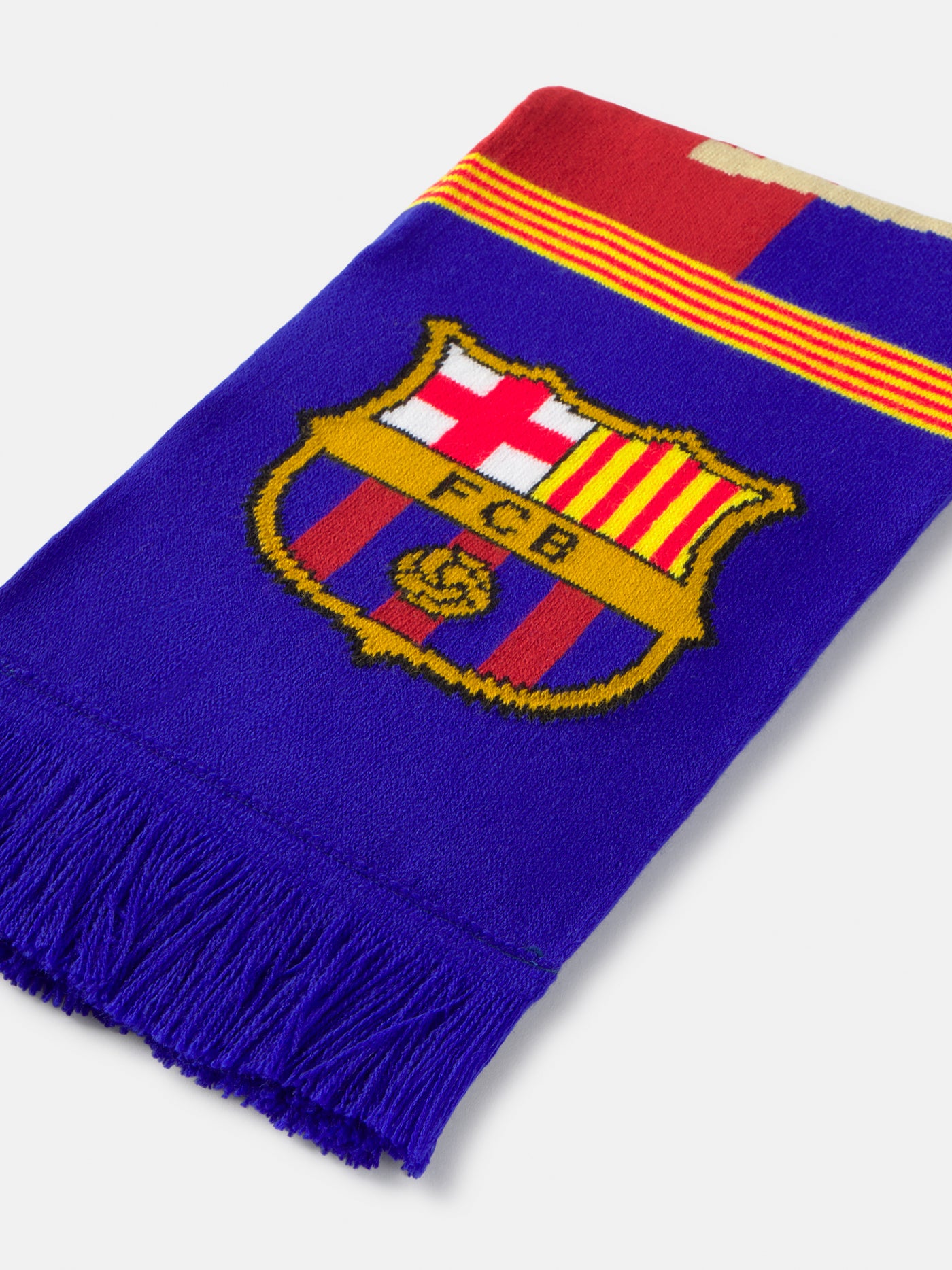 FC Barcelona scarf featuring the club's crest, bold red and blue stripes, and the partial text "FC BARCELON" in beige, with a yellow and red Catalan flag detail across the middle.