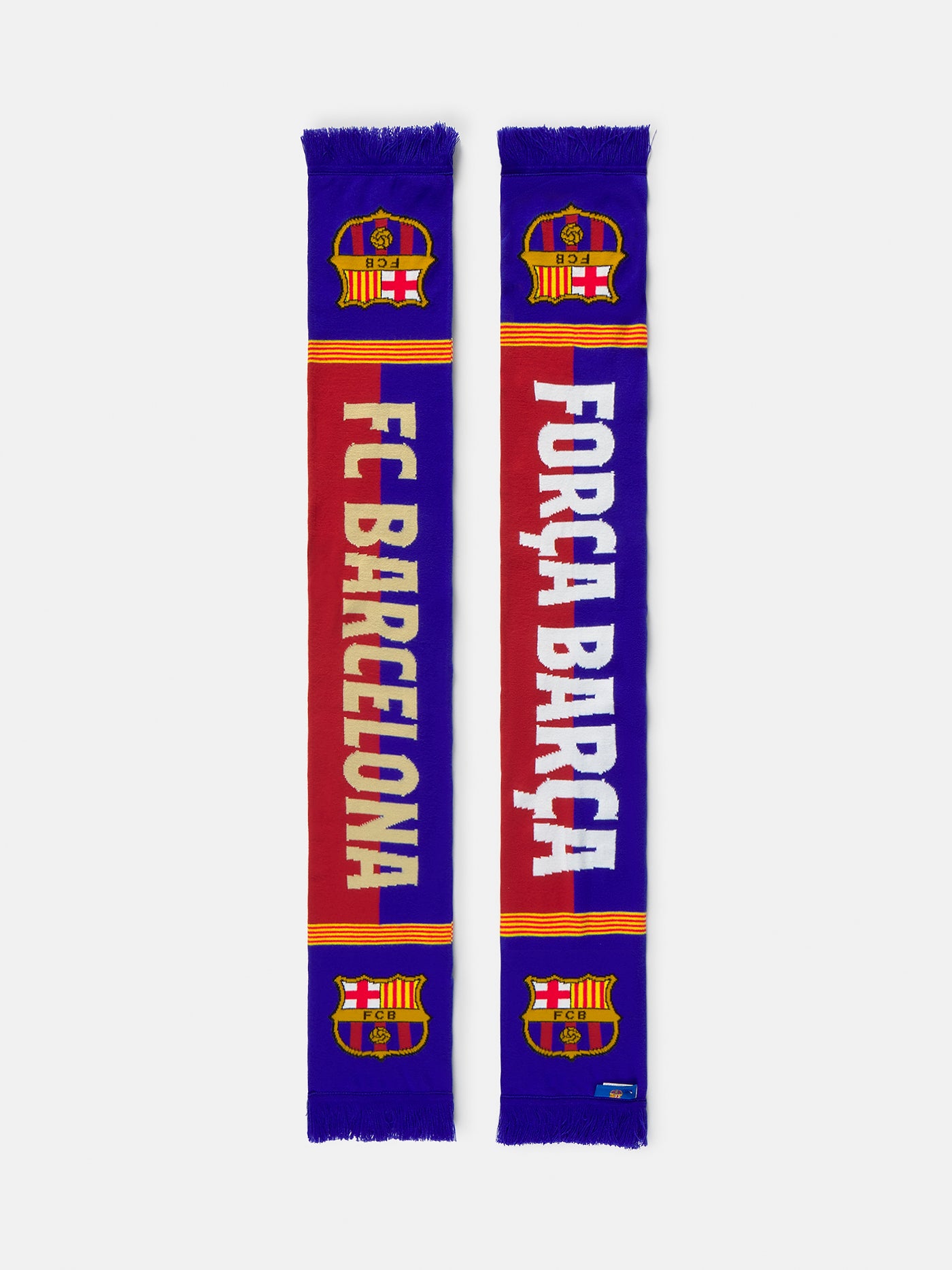 FC Barcelona scarf featuring the club's crest, bold red and blue stripes, and the partial text "FC BARCELON" in beige, with a yellow and red Catalan flag detail across the middle.