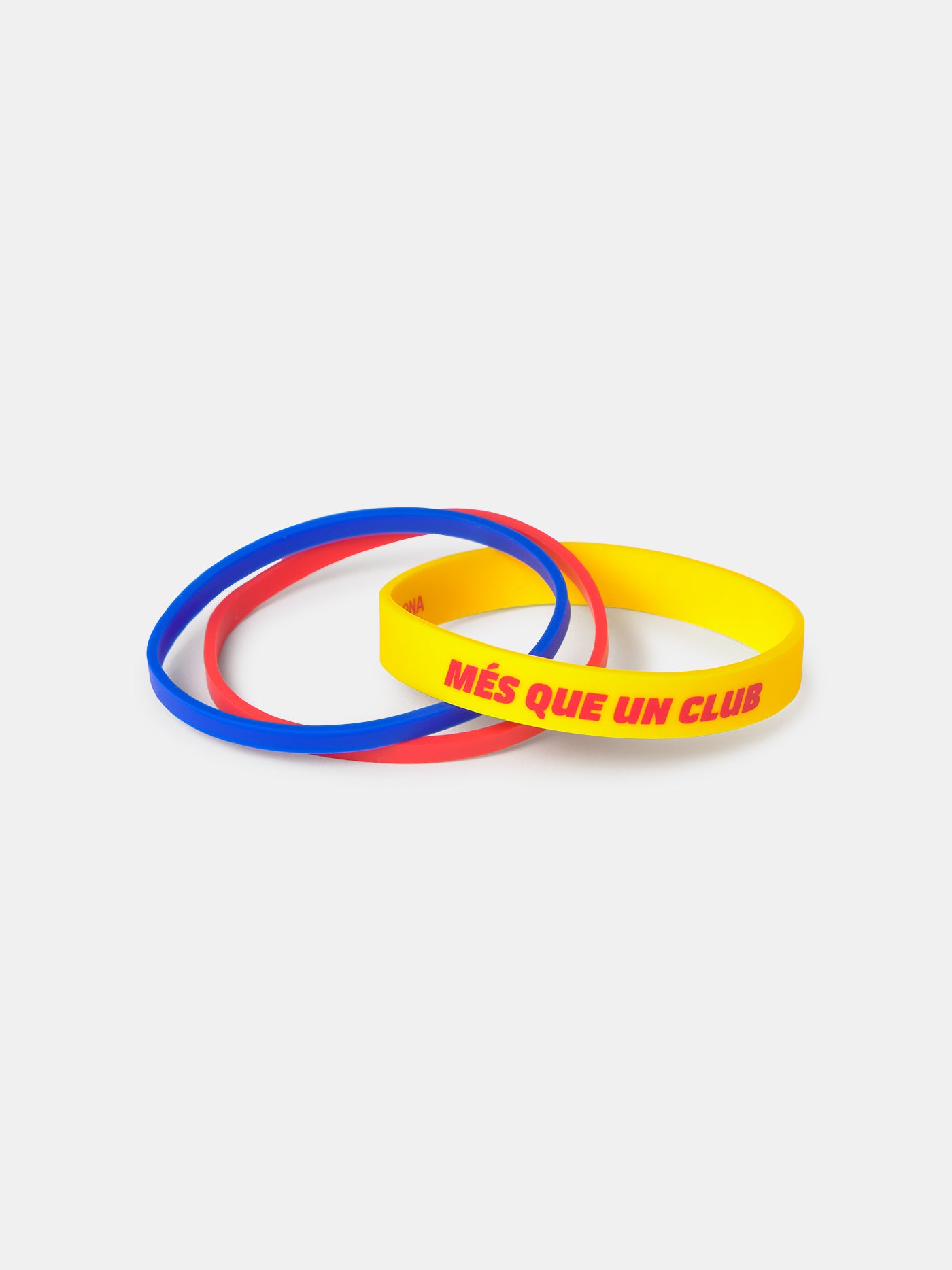 Set of three silicone wristbands in blue, red, and yellow, with the yellow one featuring the phrase 'MÉS QUE UN CLUB' in red letters