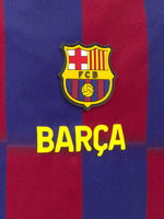 Striped red and blue drawstring backpack with FC Barcelona crest, 'Barça' text on the front, and side mesh pockets.