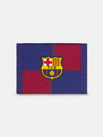 Blue and red fabric wallet with yellow 'Barça' text, displayed in FC Barcelona branded packaging