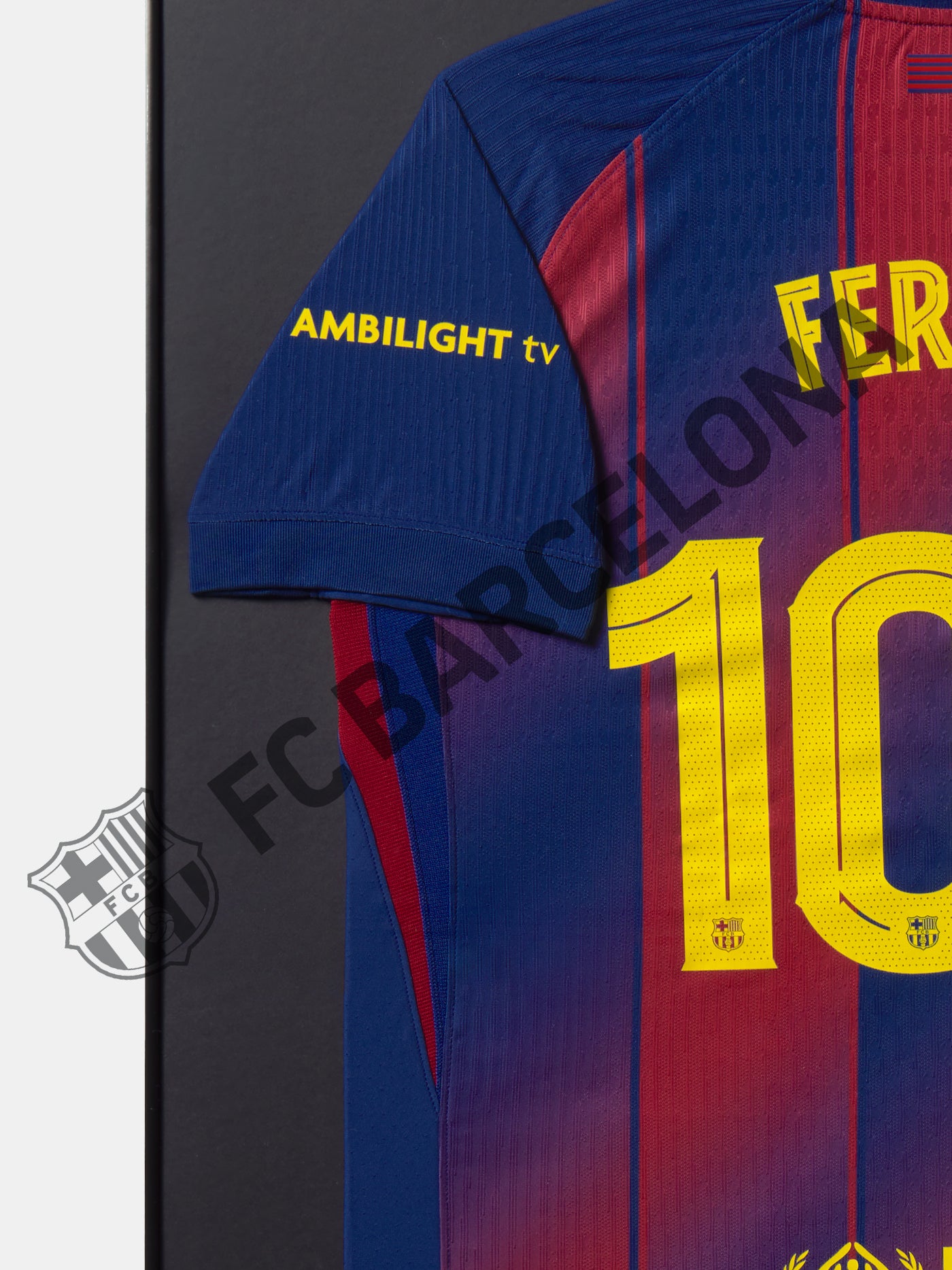 Camiseta del FC Barcelona enmarcada con el nombre Fermín y número 100 en la espalda, diseño azul y grana con detalles en amarillo y logotipo UNHCR ACNUR.