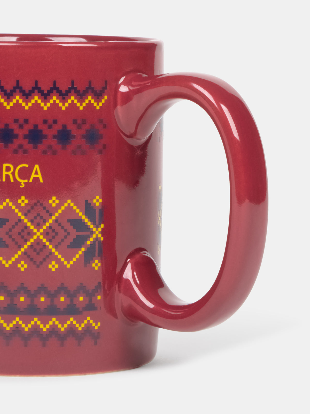 Primer plano de una taza roja brillante de FC Barcelona con un patrón geométrico de colores y asa curvada.