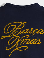 Close-up of a navy FC Barcelona sweater with large yellow script reading “Barça Dreams” across the chest.