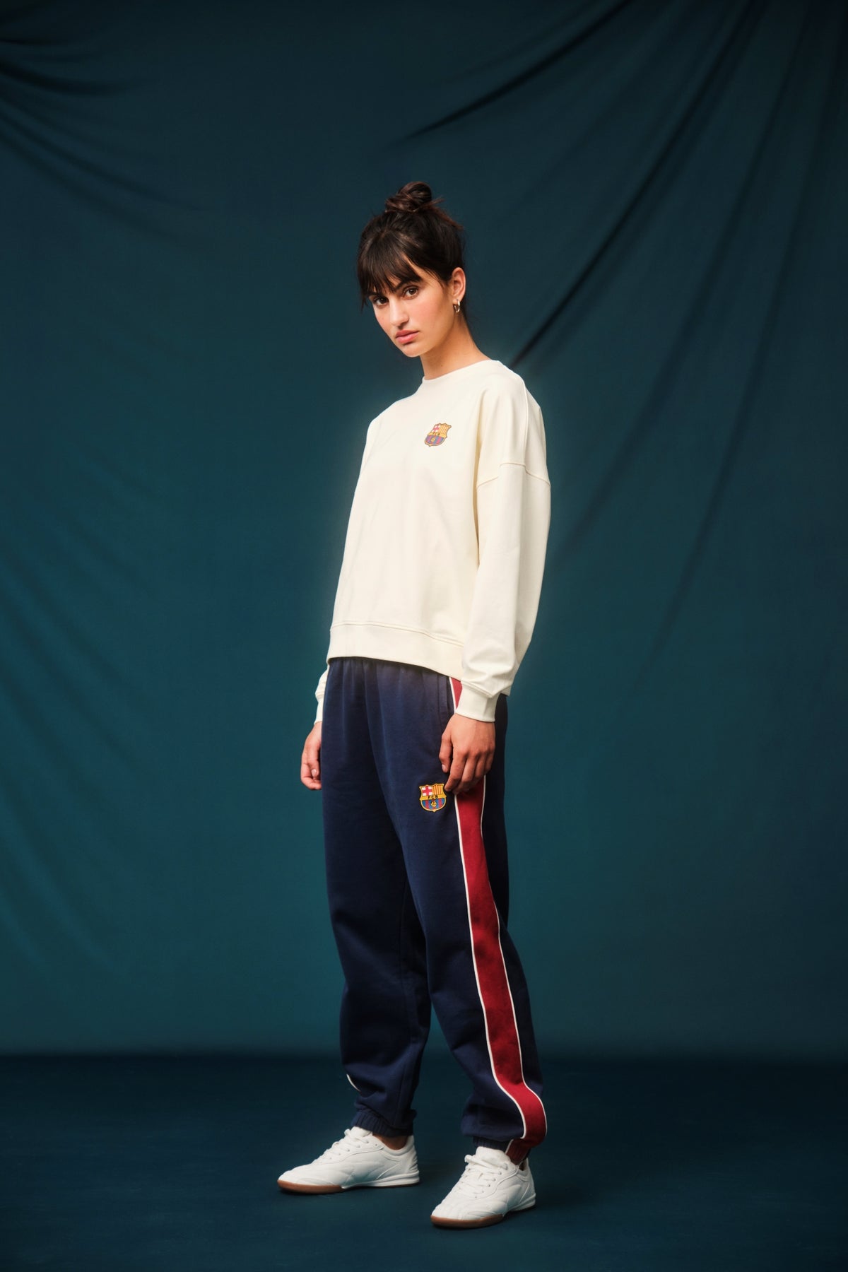 Navy blue FC Barcelona track pants with red side panels and white piping. The pants feature the club crest on the upper left leg and have an elastic waistband and cuffs for a comfortable fit.









