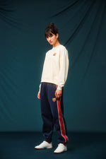 Navy blue FC Barcelona track pants with red side panels and white piping. The pants feature the club crest on the upper left leg and have an elastic waistband and cuffs for a comfortable fit.









