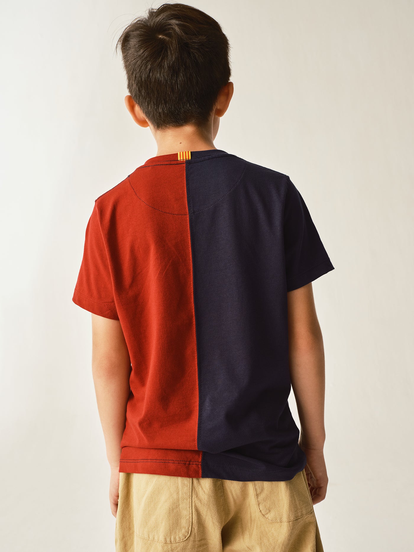 half navy and half red FC Barcelona t-shirt with a large vintage-style club crest in the center.