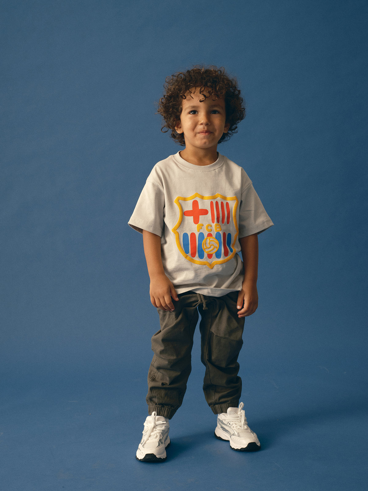 light grey FC Barcelona t-shirt featuring an oversized colorful club crest on the front.