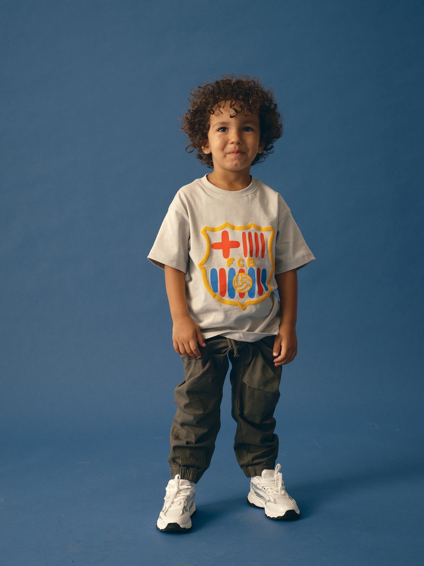 light grey FC Barcelona t-shirt featuring an oversized colorful club crest on the front.