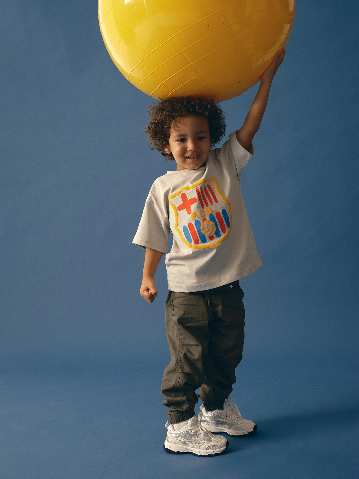light grey FC Barcelona t-shirt featuring an oversized colorful club crest on the front.