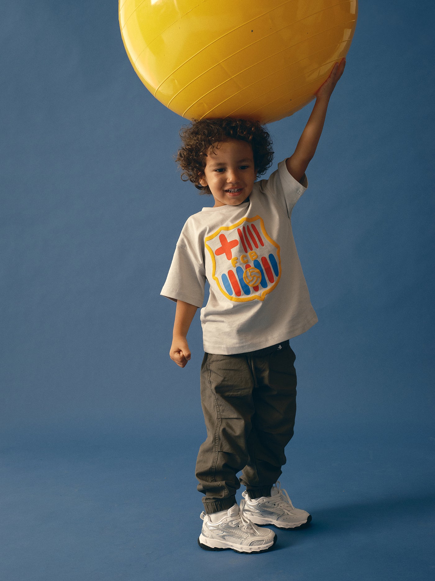 light grey FC Barcelona t-shirt featuring an oversized colorful club crest on the front.