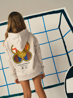 White FC Barcelona hoodie featuring a unique back design with a four-petal flower made of circular emblems: the St. George cross, Catalan flag, blaugrana stripes, and a central golden football. Below the graphic, the text reads “Futbol Club Barcelona” and “Més que un club” along with minimalist logos.